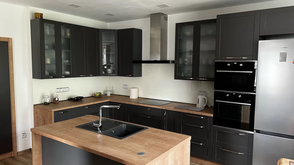 Moderní černá kuchyně na míru s dřevěnými detaily a vestavěnými spotřebiči od A-max Tábor